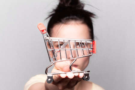 Woman showing mini shopping cartの写真素材