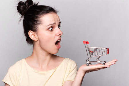 Woman with a toy trolley from a supermarket in her handsの写真素材