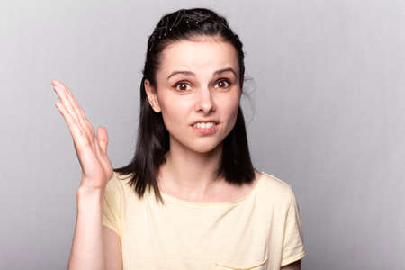 Lovely girl in a yellow t-shirt on a grayの写真素材