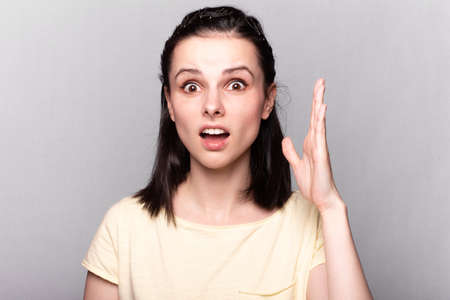 Lovely girl in a yellow t-shirt on a gray