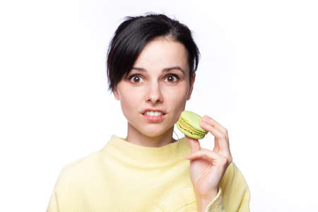 Close up profile of charming woman want to bite tasty  macaron