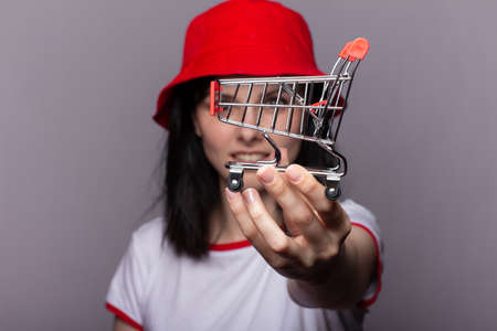 Closeup portrait of businesswoman showing mini shopping cartの写真素材