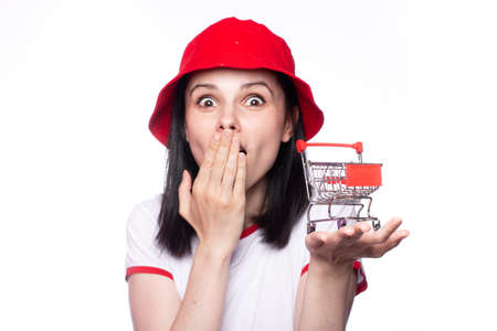 Handsome woman collision with shopping trolley. Sale, discount and online shopping concept. Girl with mini shoppingの写真素材