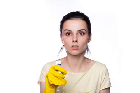 Woman wiping surface with cloth wearing apron and rubber glovesの写真素材