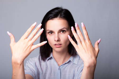 woman showing her hands, gray studio backgroundの写真素材
