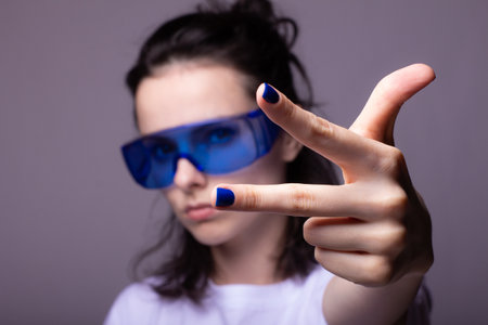 funny girl in big blue glasses, gray backgroundの写真素材