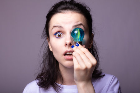 beautiful girl in a white t-shirt holds a blue light bulb in her hands