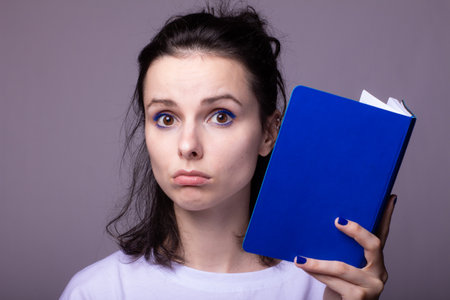 woman with blue notebook in her handsの写真素材