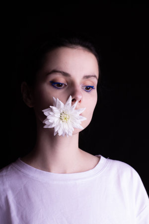 woman with a flower in her mouth, black background