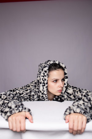young woman sitting at a table in the studio
