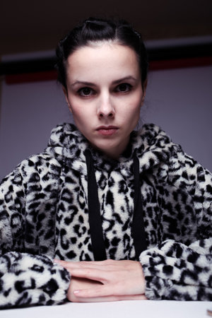 woman in hoodie, studio portrait on gray backgroundの写真素材