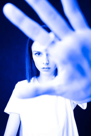 woman stretched her hand palm forward, black backgroundの写真素材