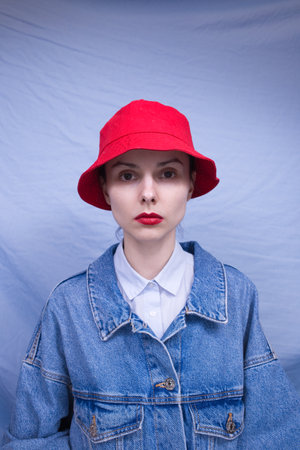 woman in red panama, blue background