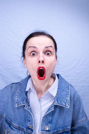 woman with red lips in blue clothes on a blue backgroundの写真素材