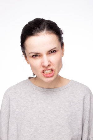 emotional woman in a gray sweatshirt, white background. high quality photo
