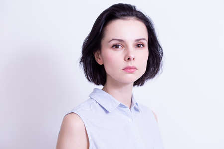 woman in a blue sleeveless office shirt, light background. high quality photo