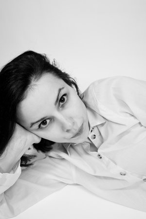 brunette woman lies on the floor, black and white photo. high quality photoの写真素材