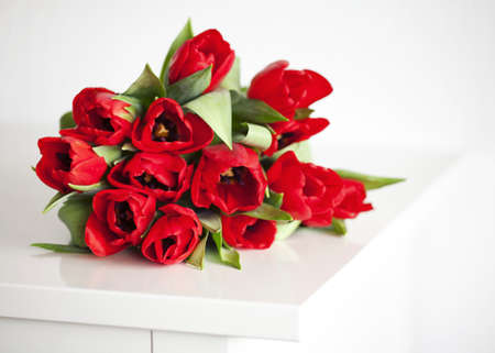 red tulips lying on white tableの写真素材