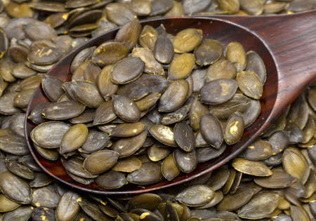 pumpkin seeds in a wooden spoonの写真素材