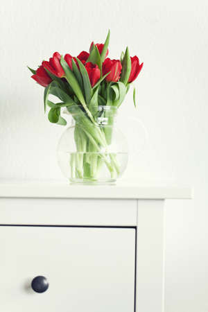 beautiful red tulips on a white tableの写真素材