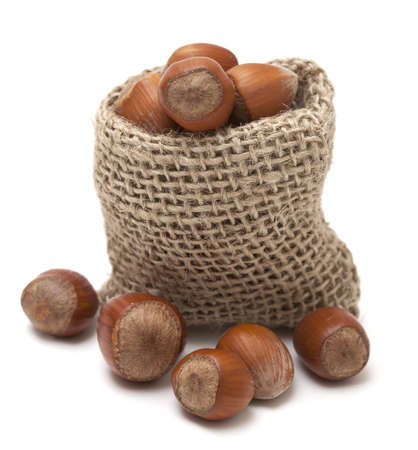 hazelnuts in a miniature burlap sack isolated on whiteの写真素材