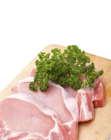 pieces of meat and bunch of pasrley  on wooden board isolated on white backrgoundの写真素材