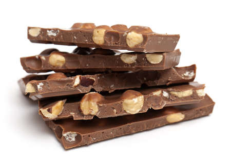 milk chocolate with hazelnuts isolated on whiteの写真素材