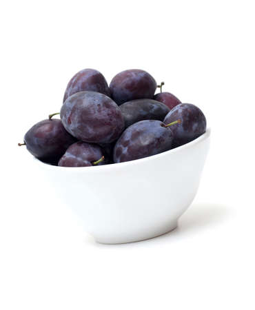 bowl with fresh plums on white backgroundの写真素材