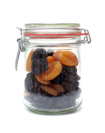 jar with dried apricots and plums on white backgroundの写真素材