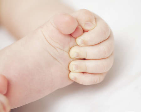 baby holding his feetの写真素材