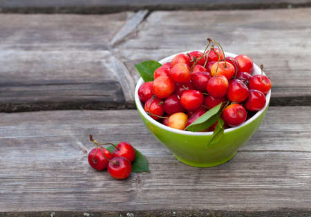 bowl with cherries on wooden tableの写真素材