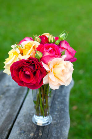 beautiful bouquet of different roses on wooden tableの写真素材