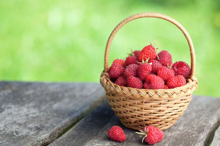 fresh raspberry in a basket on wooden tableの写真素材