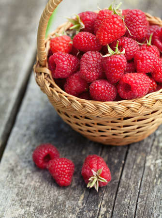 fresh raspberry in a basket on wooden tableの写真素材