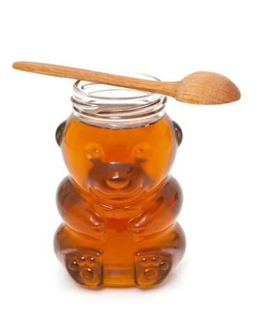 honey in bear-shaped jar isolated on whiteの写真素材