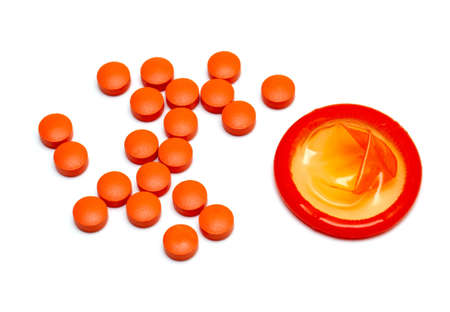 orange condom and pills isolated on white background