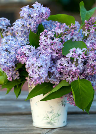 lilac flowers in a bucket on garden table