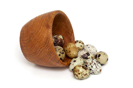 quail eggs in a wooden bowl isolated on white backgroundの写真素材
