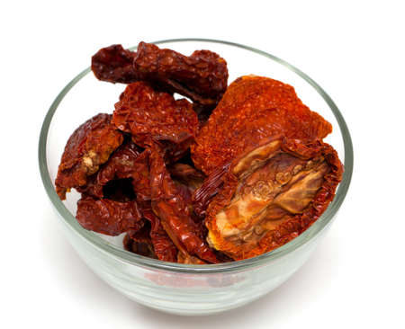 dried tomatoes in a glass bowl isolated on white backgroundの写真素材