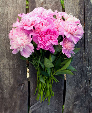 bunch of peonies on wooden surfaceの写真素材
