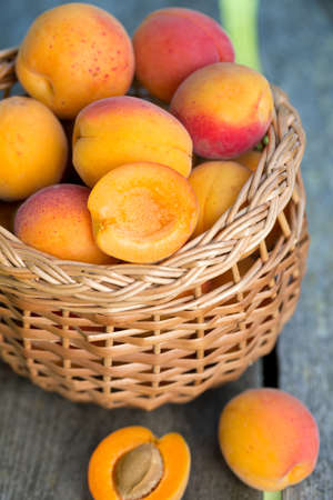 apricots in a basket on wooden backgroundの写真素材