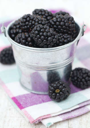 blackberries in a bucket on kitchen towelの写真素材