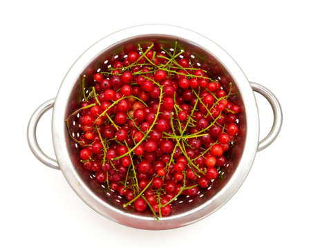 red currant in metallic collander isolated on white backgroundの写真素材