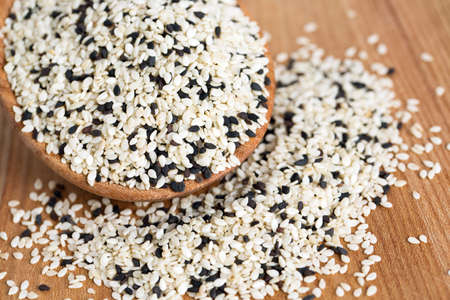 black and white sesame seeds on wooden tableの写真素材