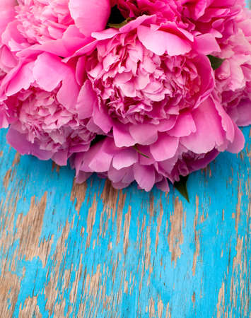 bunch of peonies on wooden surfaceの写真素材