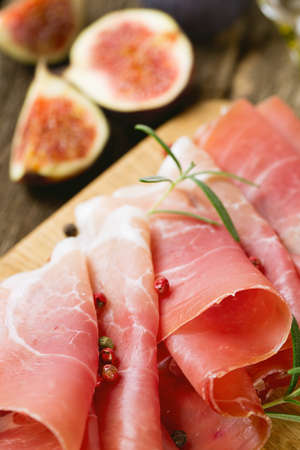 sliced prosciutto on a wooden boardの写真素材