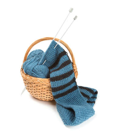 striped scarf on knitting needles over white
