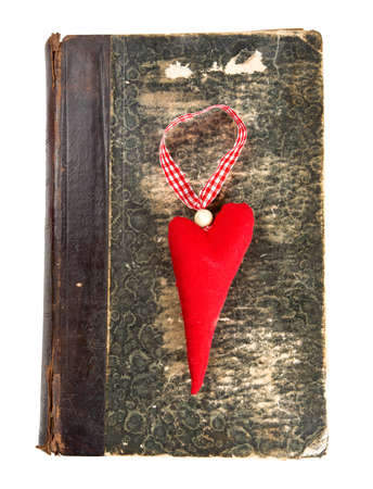 heart-shaped decoration on old book isolated on whiteの写真素材