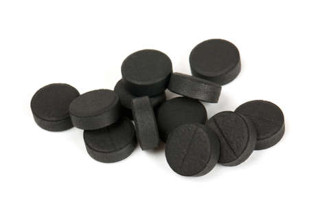 black pills (activated coal) isolated on whiteの写真素材