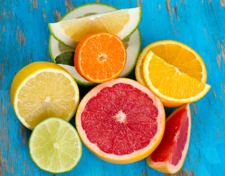citrus fruit mix on blue wooden surfaceの写真素材